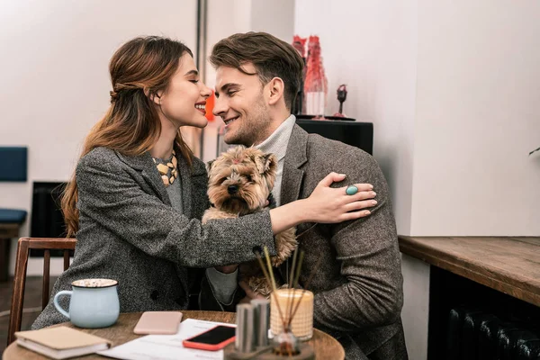 Ung familj kramas när du besöker ett café med deras sällskapsdjur — Stockfoto