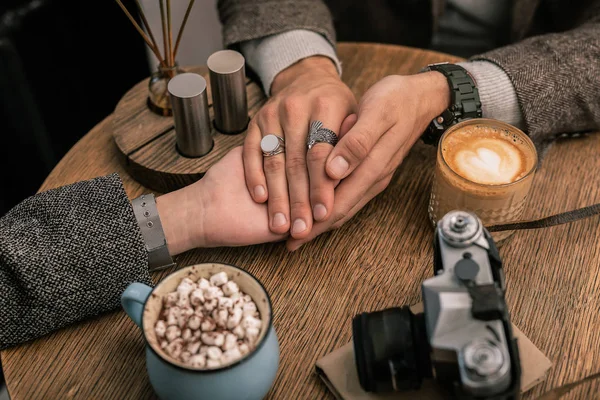 Чоловік тримає жіночі руки, сидячи в кафе — стокове фото