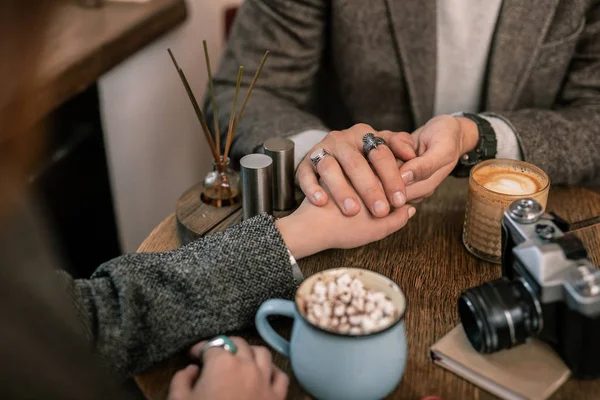 Hombre sosteniendo las manos de mujer mientras está sentado en un café — Foto de Stock