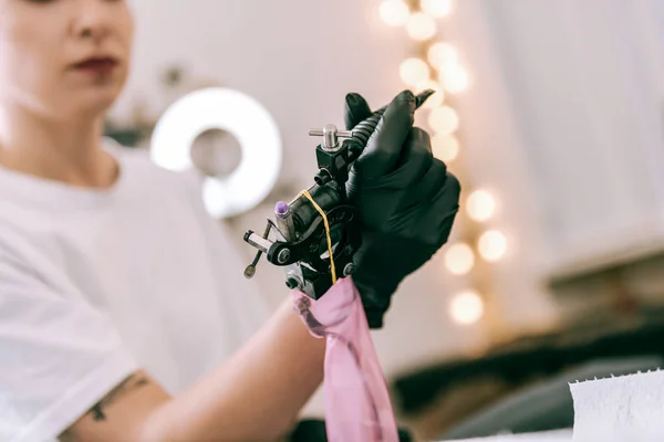 Maestro del tatuaje femenino sosteniendo una máquina especial con sus manos — Foto de Stock