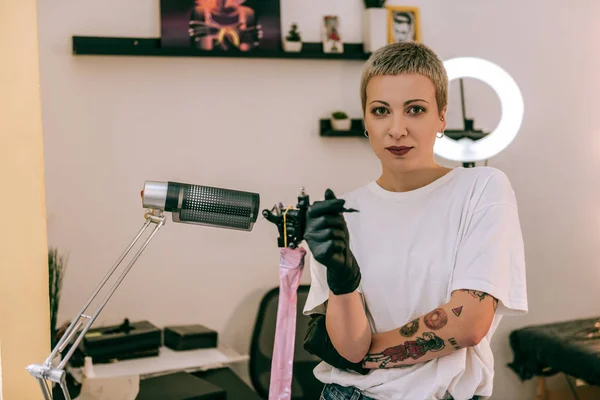 Short-hair blonde master with big eyes having her hands covered in tattoo — Stock Photo, Image