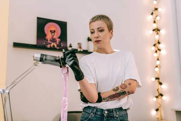 Good-looking stylish tattoo master showing her own tattoos — Stock Photo, Image