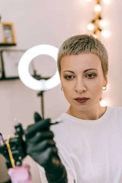 Maestro femenino con pelo corto y ojos grandes observando detalles — Foto de Stock