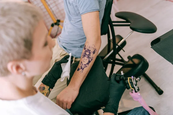 Maestro profesional del tatuaje que lleva la máquina y el paño especiales — Foto de Stock