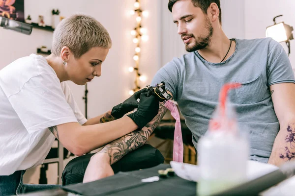 Mestre extraordinário concentrado fazendo coloração para tatuagens passadas — Fotografia de Stock