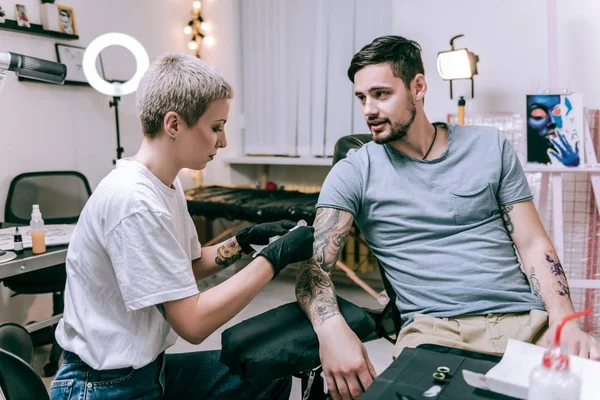 Tatuagem concentrada artista coberto de tatuagens fazendo sombreamento — Fotografia de Stock