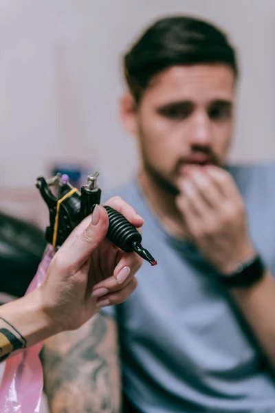 Professional tattoo artist with accurate manicure carrying tattoo machine — Stock Photo, Image