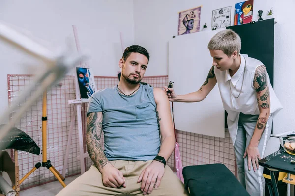 Resimlerde şık kısa saçlı dövme sanatçısı beden ile kaplı — Stok fotoğraf