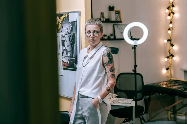 Mujer atractiva con apariencia inusual trabajando como maestro del tatuaje — Foto de Stock
