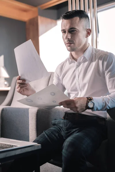 Empresario con pantalones cuadrados sosteniendo documentos en las manos — Foto de Stock