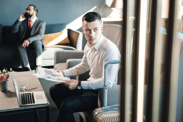 Guapo joven hombre de negocios sentado en sillón trabajando duro — Foto de Stock