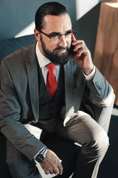 Κομψό ώριμο επιχειρηματίας φορώντας την κόκκινη γραβάτα καλώντας τη σύντροφό του — Φωτογραφία Αρχείου