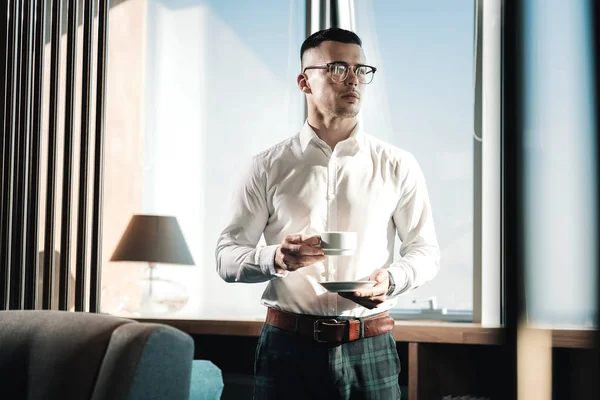 Homem de negócios elegante vestindo camisa quadrada escura bebendo um pouco de café — Fotografia de Stock