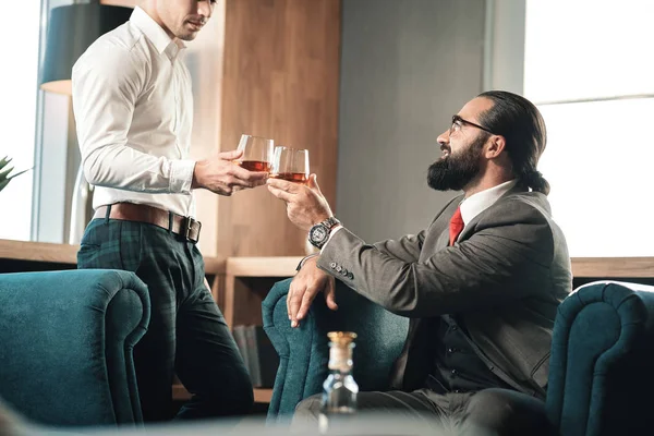 Mladý zaměstnanec spojení svého šéfa v restauraci pití whisky — Stock fotografie