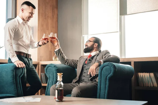 Elegante joven guapo bebiendo whisky con su jefe — Foto de Stock