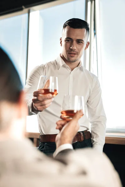 Jonge knappe man drinken van wat alcohol met zijn baas — Stockfoto