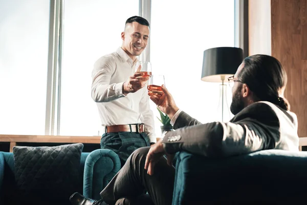 Joven bebiendo whisky con su socio de negocios — Foto de Stock