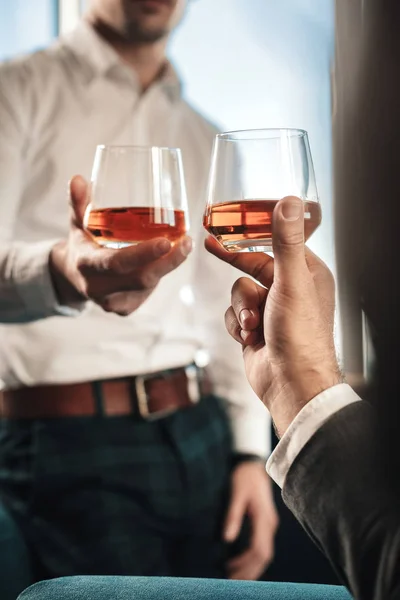 Мужчина в брюках в квадрате пьет виски с деловым партнером — стоковое фото
