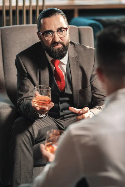 Onun stajyer konuşmak koyu gri kostüm giyen olgun iş adamı — Stok fotoğraf