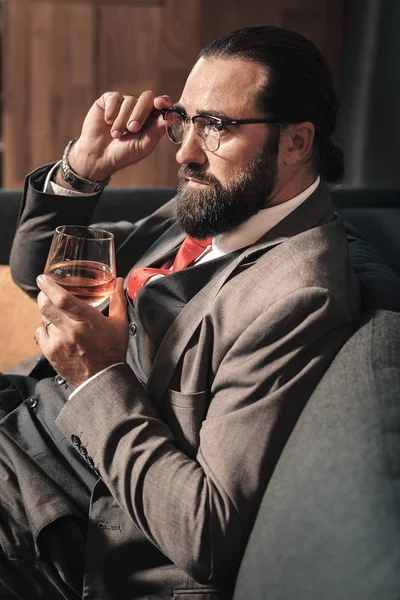 Bebaarde zakenman dragen rode stropdas drinken sommige cognac — Stockfoto