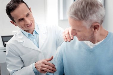 Olumlu memnun Doktor omzuna masaj yapıyor