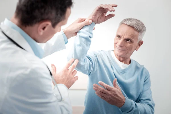 Positive delighted male person looking at his doctor — Stock Photo, Image