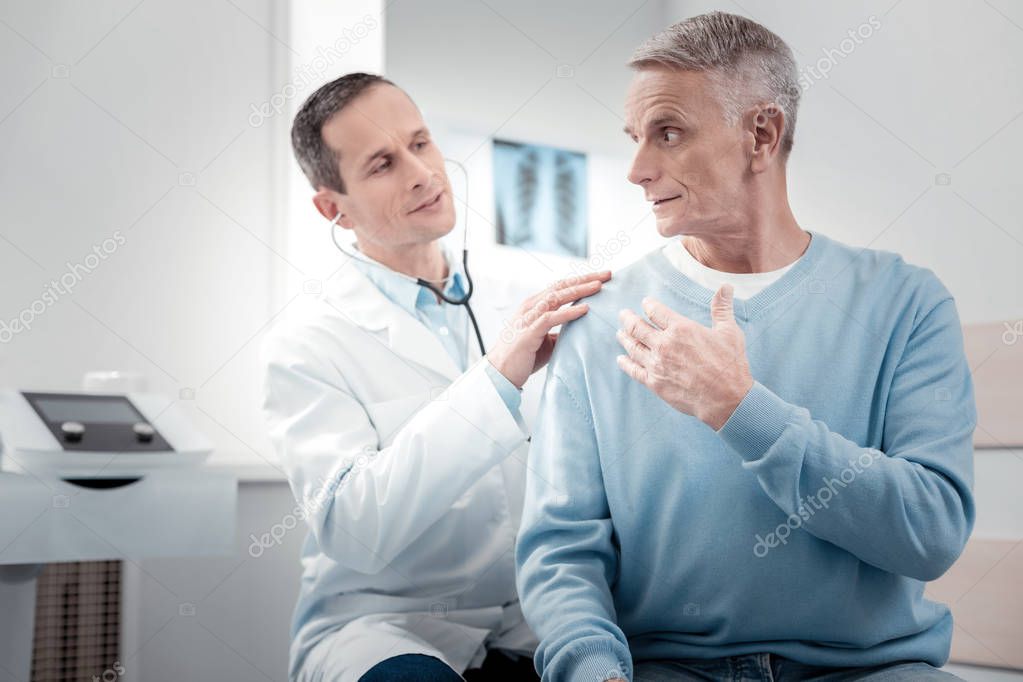 Delighted medical worker calming his visitor