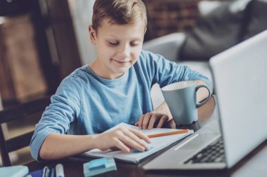 Düşünmeme izin ver. Neşeli sarışın çocuk onun notları, bakarken kafa selam