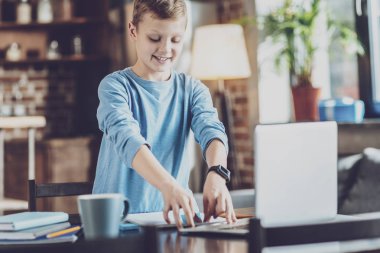 Neşeli sarışın çocuk onun masanın ayakta