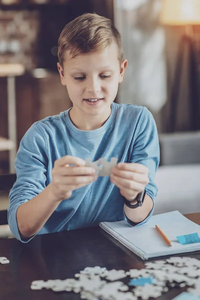 Pequeña persona masculina atenta mirando puzzles — Foto de Stock