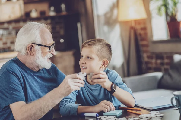 Knappe jongen verzamelen puzzels met opa — Stockfoto