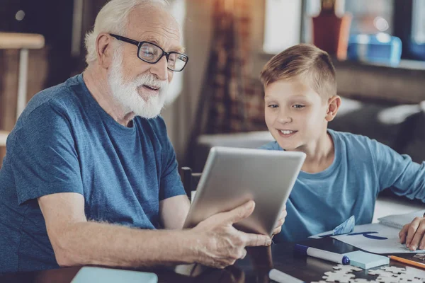 Positive delighted pensioner spending time with grandson — Stock Photo, Image