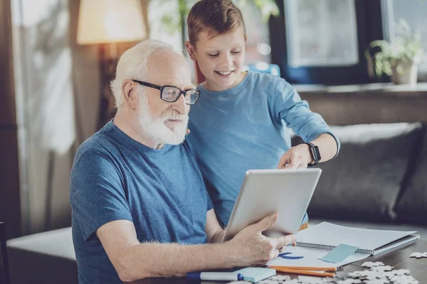 Aufmerksame Rentnerin blickt auf Bildschirm des Tablets — Stockfoto