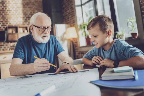 Positivo chico encantado escuchando a su abuelo — Foto de Stock