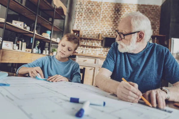 Серьезный бородатый мужчина смотрит на своего внука — стоковое фото