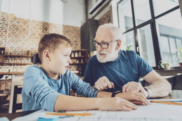Positive delighted granddad talking to his grandson — Stock Photo, Image