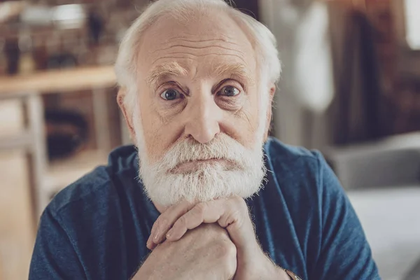 Portrait of serious grandfather that looking at you