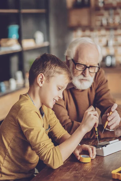 Delighted boy repairing his gadget — Stock Photo, Image