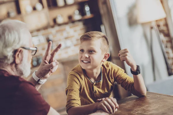 Attentive kid looking at his grandfather — Stock Photo, Image