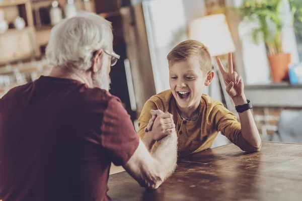 Alegre escolar jugando con su abuelo — Foto de Stock