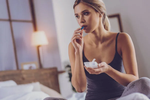 Encantadora jovem mulher que está prestes a tomar cápsula azul — Fotografia de Stock