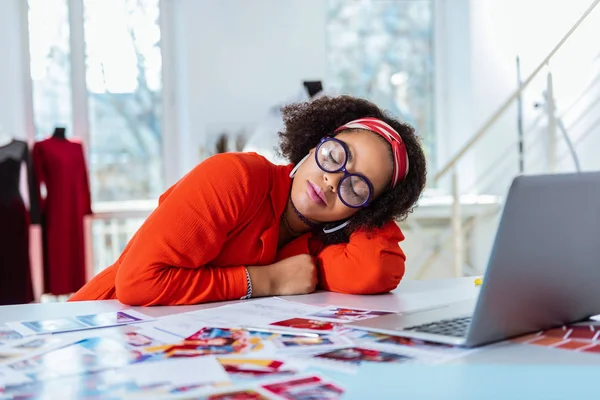 Exhausted unusual lady in circled bulky glasses sleeping on her workplace