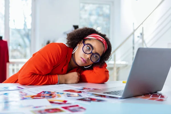 Upset young extravagant woman leaning on her desk — Stock Photo, Image