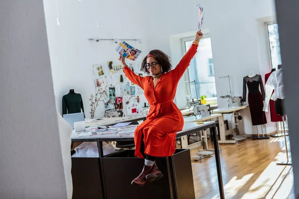 Joyful African American girl sträcker sig själv medan bär foton — Stockfoto