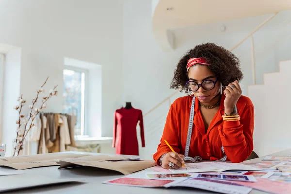 Short-haired curly designer being busy with new ideas