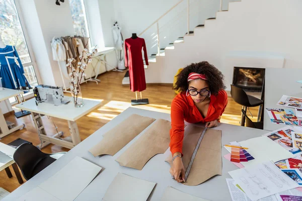 Femme attentive et précise mesurant les modèles papier de sa future création — Photo