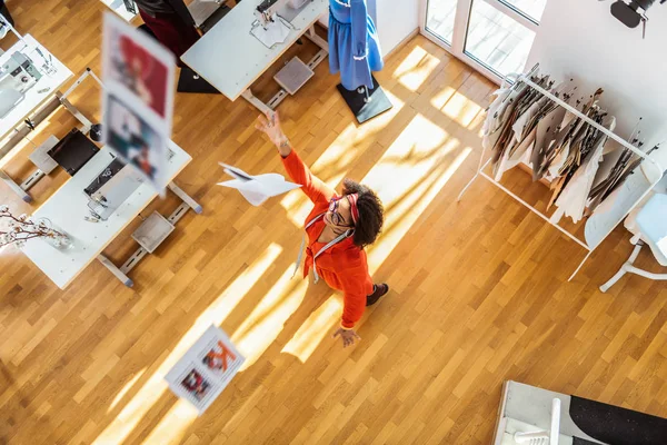 Активная забавная леди в красном платье развлекается в своей студии — стоковое фото