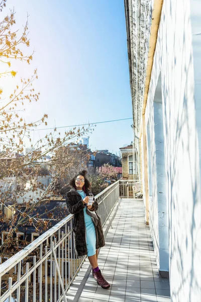 Radostné módní žena odpočívá na její široký balkon — Stock fotografie