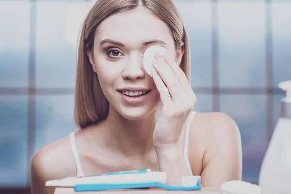 Mujer joven quitando maquillaje de ojos — Foto de Stock