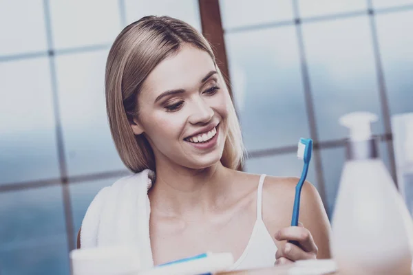 Optimistisk kvinna som tittar på tandborsten — Stockfoto